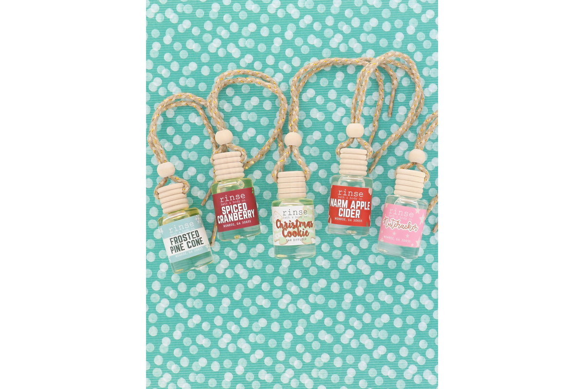 Holiday car diffuser flat lay — five ready-to-hang scents on teal polka