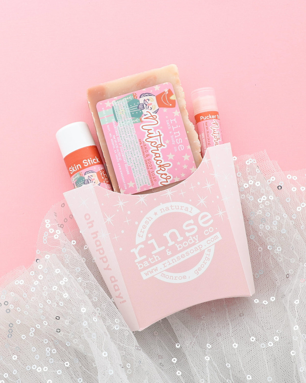 Nutcracker gift set in a pink fry carton with soap, Skin Stick and Pucker Stick on pink with sparkly white tulle