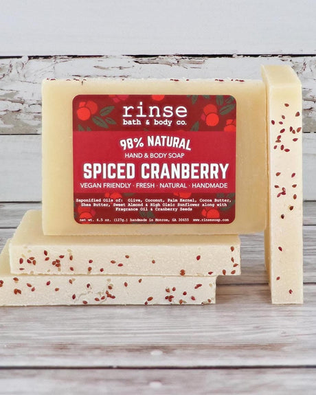 Spiced Cranberry mini bar standing beside a seed-flecked stack — rustic whitewashed wood daylight