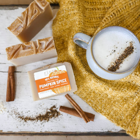 Pumpkin Spice bars flat-laid with a cinnamon-dusted latte, cinnamon sticks and a mustard knit sweater — nutmeg, clove and brown sugar, the scent inside the fry-box gift set. Rinse Bath & Body Co.