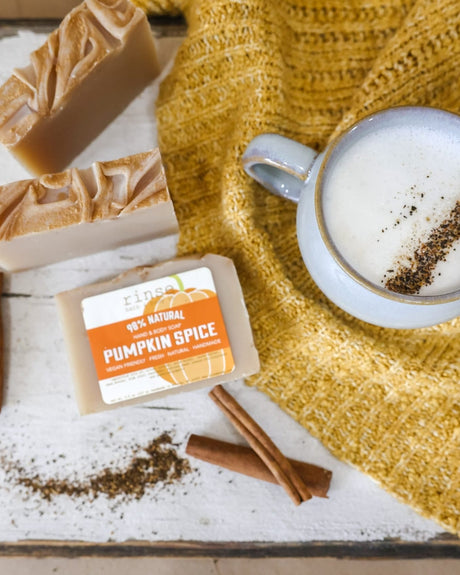 Pumpkin Spice bars flat-laid with a cinnamon-dusted latte, cinnamon sticks and a mustard knit sweater — nutmeg, clove and brown sugar, the scent inside the fry-box gift set. Rinse Bath & Body Co.