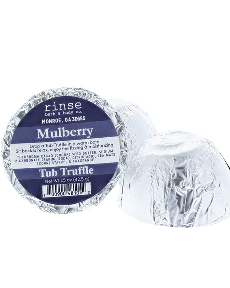 A navy-labelled Mulberry Tub Truffle in silver foil beside a second one cut open to show the cocoa butter dome — dark, jammy, and the whole room knows. Rinse Bath & Body Co.