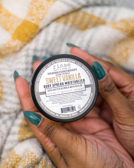 Sweet Vanilla body spread scooped and worked into skin — a thick shea-butter moisturizer in warm bourbon vanilla. Rinse Bath & Body Co.