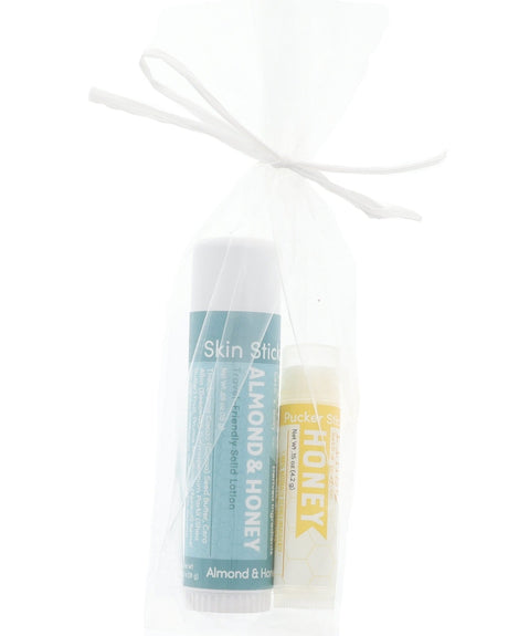 Almond & Honey Skin Stick and Honey Pucker Stick tucked in a sheer white mesh bag — gift-ready duo on bright white