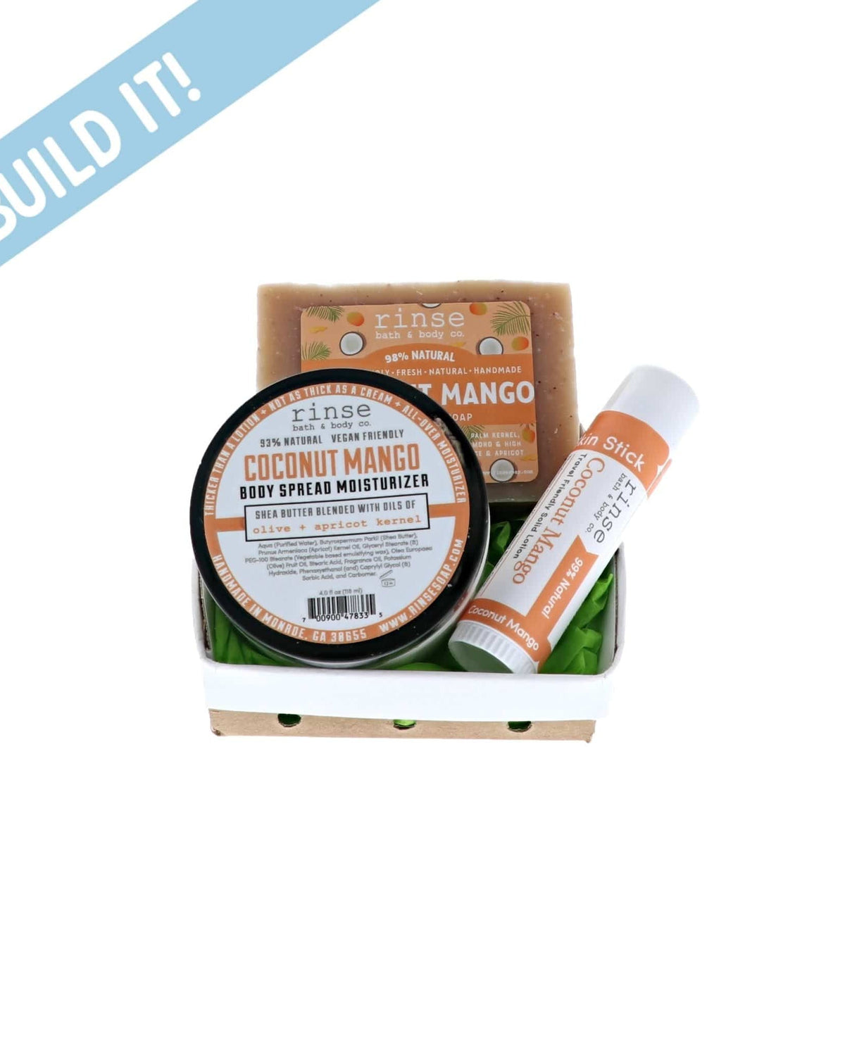 Coconut Mango Moisture Bundle sits in a white ceramic berry basket — green crinkle paper and Build It banner on bright white