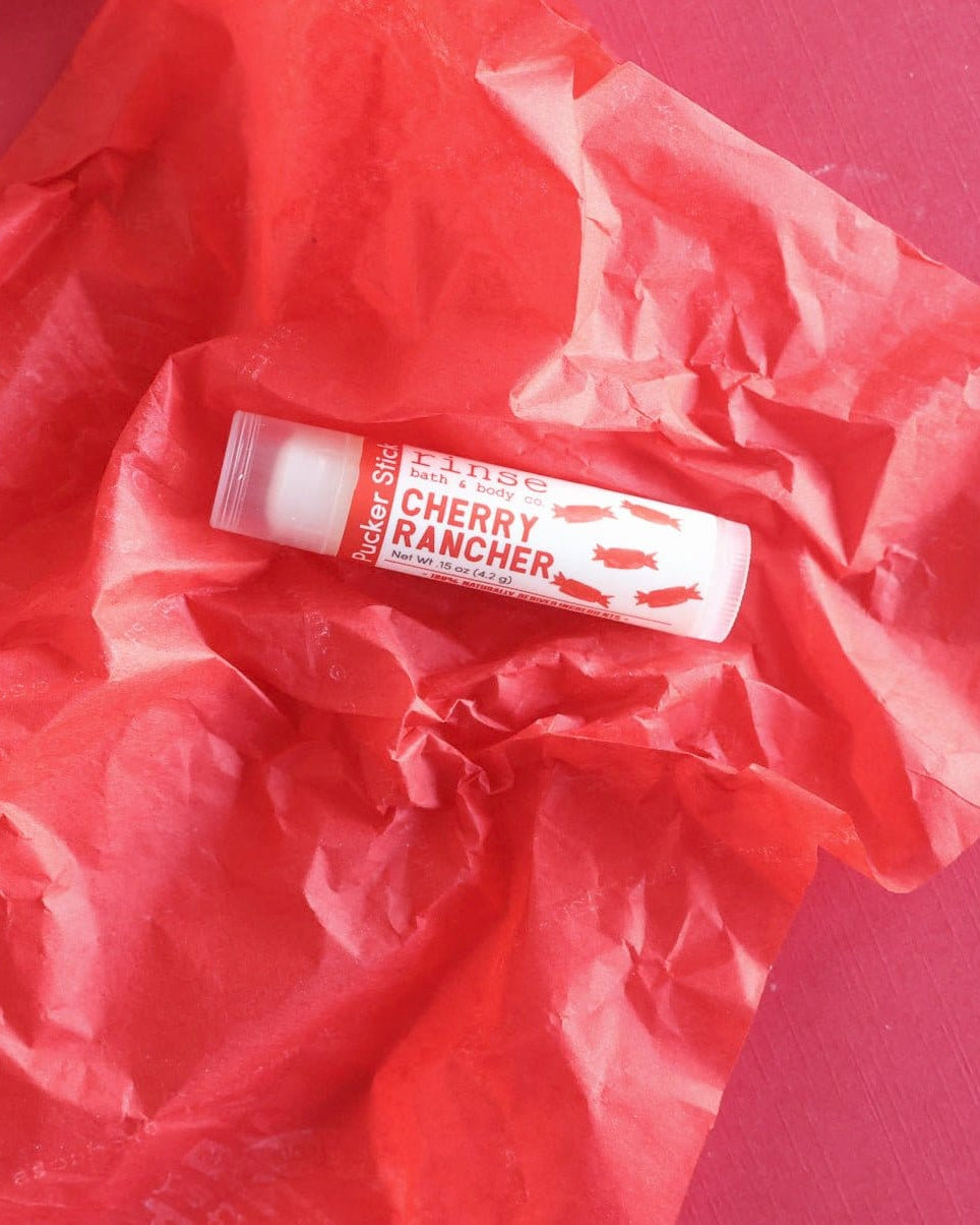 Lip balm labeled 'Cherry Rancher' on a red background
