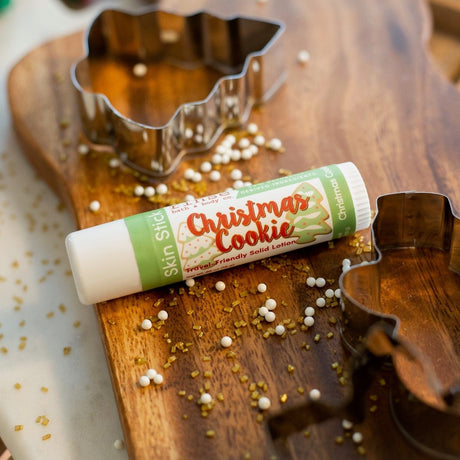 Christmas Cookie Skin Stick lifestyle on warm wood — pearl sprinkles and cookie cutters