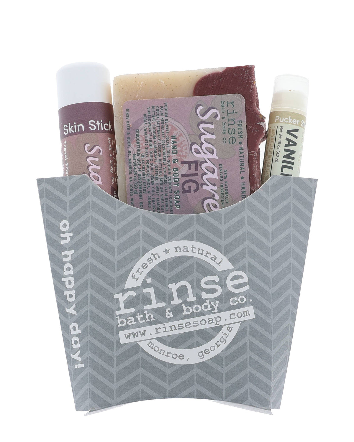 The Sugared Fig fry-box gift set in its grey chevron carton — Sugared Fig bar soap, Sugared Fig solid lotion skin stick and a Vanilla lip balm, ready to hand over. Rinse Bath & Body Co.