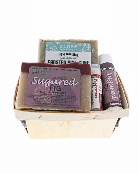 Frosted Pine and Sugared Fig holiday berry till packed with Peppermint balm and Skin Stick — wooden basket on bright white