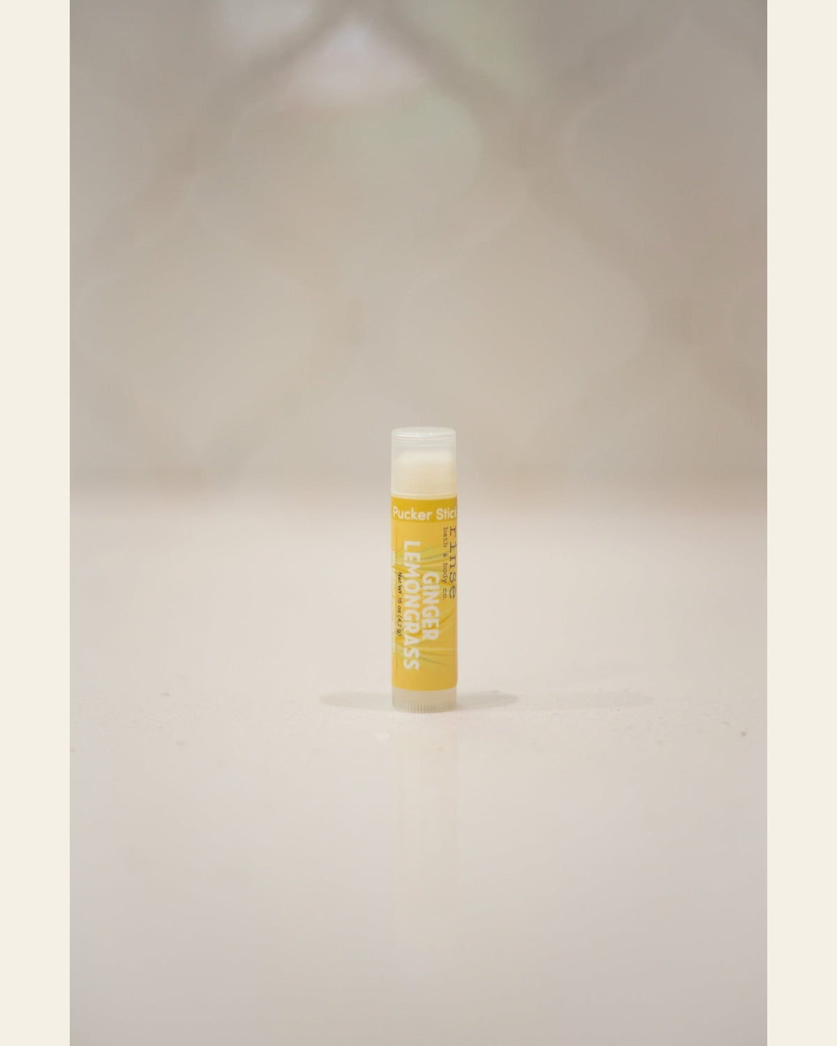 Ginger Lemongrass Pucker Stick standing upright — bold yellow label and clear cap on soft cream background