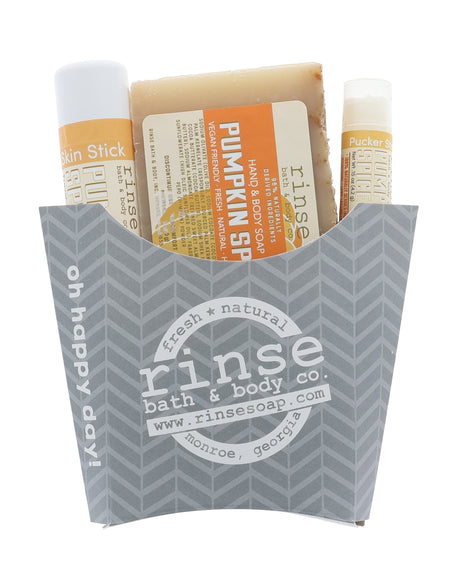 The Pumpkin Spice fry-box gift set open to show its three pieces — bar soap, solid lotion skin stick and lip balm in a kraft fry carton, ready to hand over. Rinse Bath & Body Co.