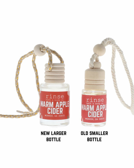 Warm Apple Cider car diffuser styled for the car, wooden cap on its cord — spiced apple, clove and brown sugar for the drive. Rinse Bath & Body Co.