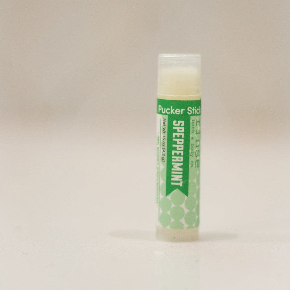 Speppermint Pucker Stick standing on a smooth countertop — green-white tube in airy bright space