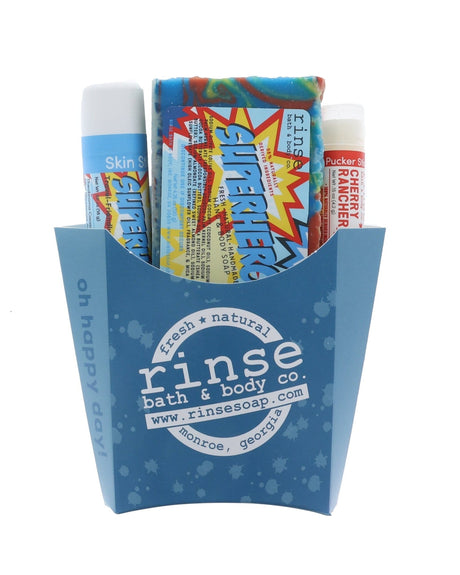 The Superhero kids gift set in its blue carton — rainbow-swirl bar soap, Superhero solid lotion skin stick and a Cherry Rancher lip balm. Rinse Bath & Body Co.