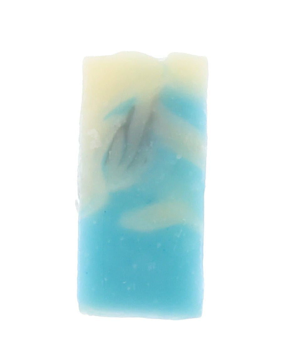 Sky-blue and cream marbled Warm Linen soap slice stands upright, dark wisps streaking the pale swirls on white.
