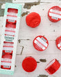 The Peppermint Shower Steamer 4-pack box on chipped white-painted wood with four red foil-wrapped pucks