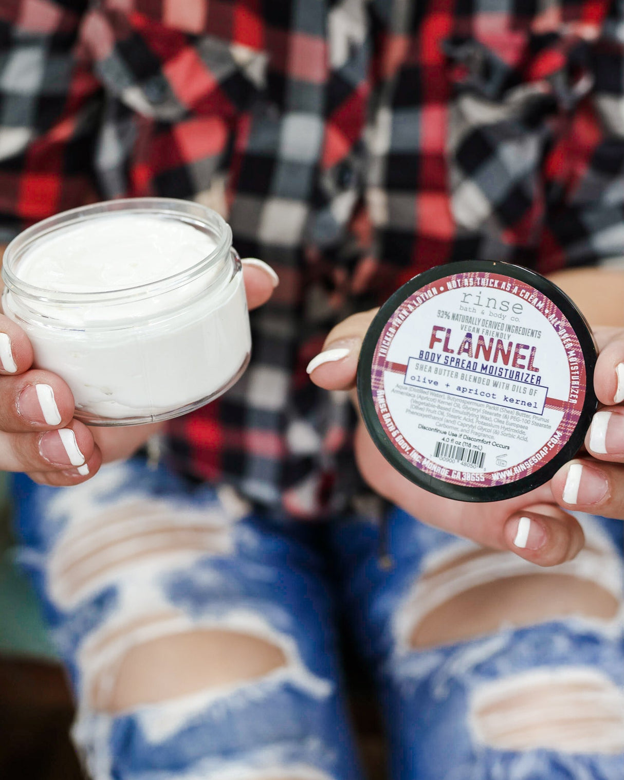 Flannel body spread in its tub with the lid off — a thick shea-butter moisturizer in sharp musk and clean cotton. Rinse Bath & Body Co.