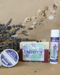 Mulberry solid lotion stick standing beside dark berries — ripe mulberry in a twist-up bar of concentrated moisture. Rinse Bath & Body Co.