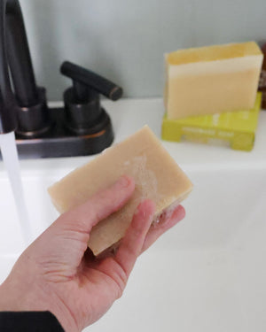 Merlot bar soap styled close, its wine-red marbling running through the cream — real merlot in the batch. Rinse Bath & Body Co.