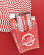 Peppermint Patti gift set in a red fry carton with soap, Skin Stick and Pucker Stick on a candy-stripe placemat on red