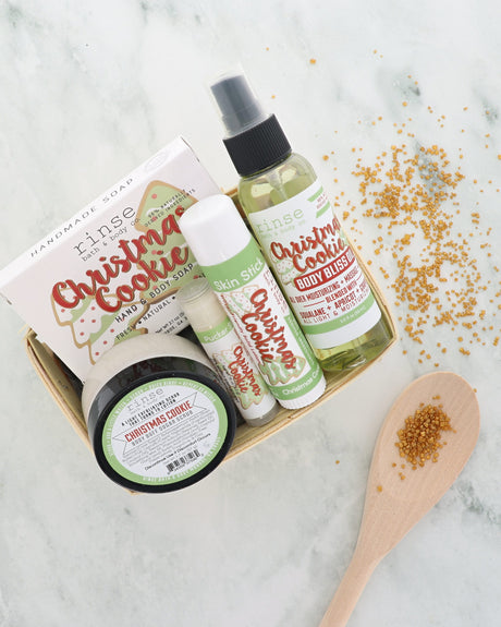 Christmas Cookie travel gift set with soap, body buff, sticks and body oil in a berry till on marble with gold sugar
