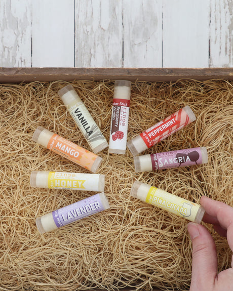 Eight Pucker Stick lip balms, Vanilla, Peppermint, Mango, Sangria, Honey and Lavender among them, fanned on excelsior
