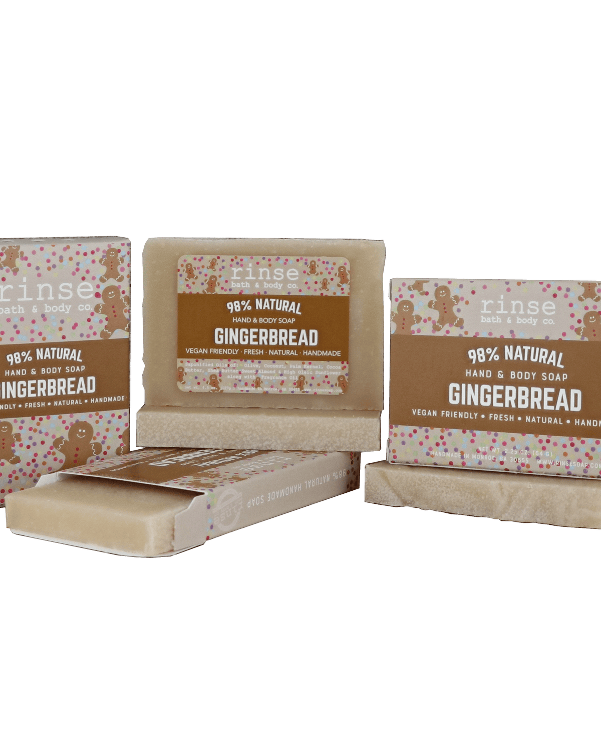 Gingerbread mini soap bars and cartons clustered on forest green — warm brown sleeves with gingerbread art