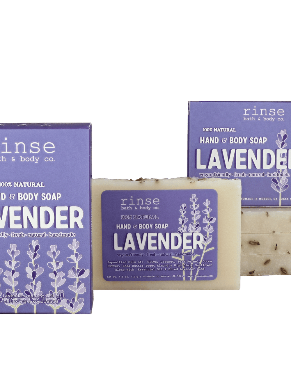 Lavender mini bar studded with buds flanked by three purple cartons — deep green surface in clean bright light