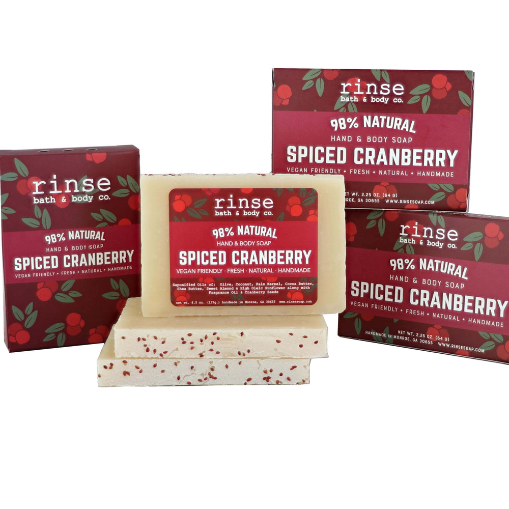Three Spiced Cranberry cartons behind stacked mini bars — cranberry-vine packs on weathered planks