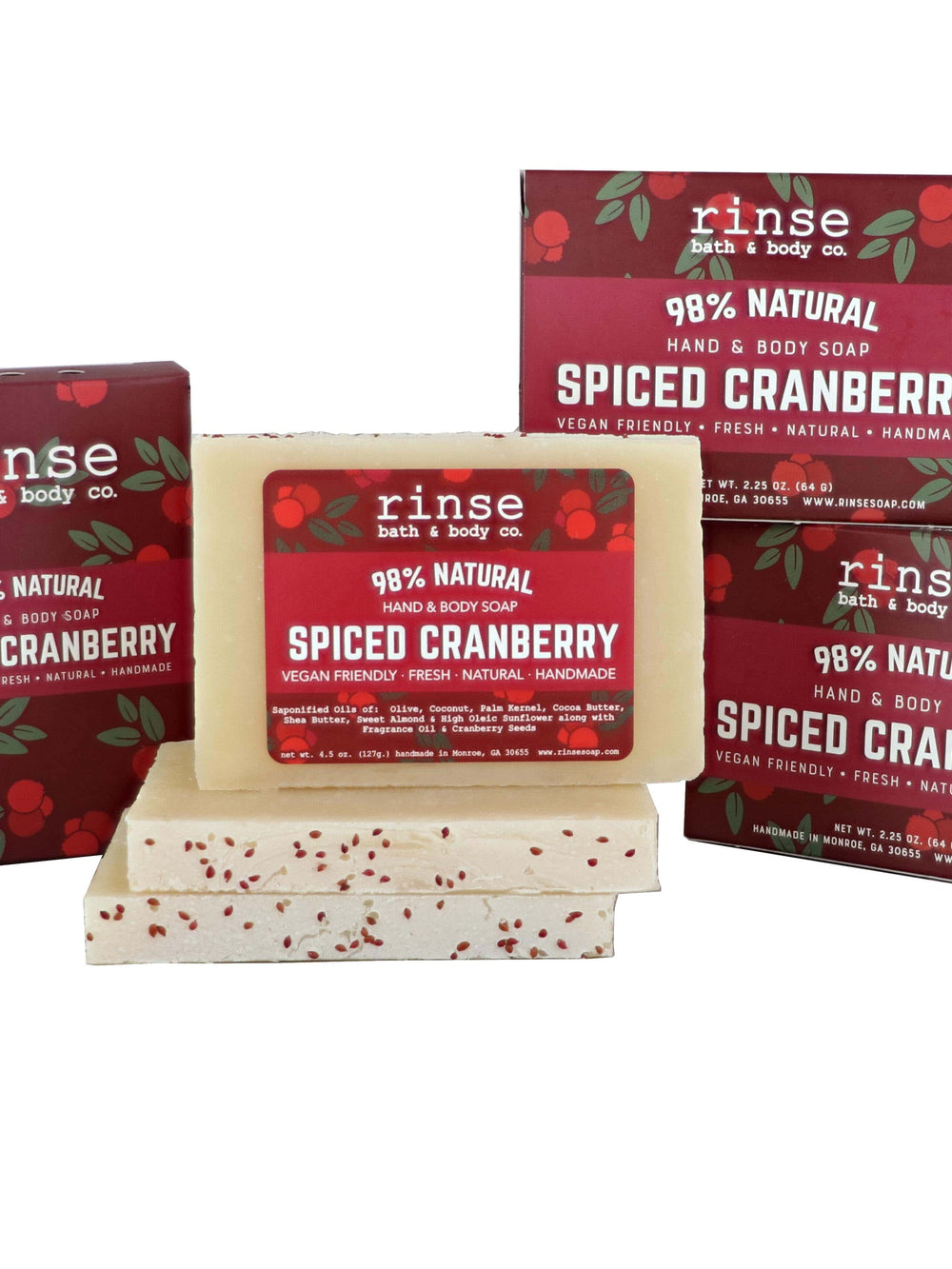 Three Spiced Cranberry cartons behind stacked mini bars — cranberry-vine packs on weathered planks