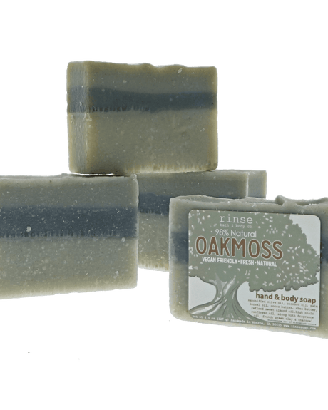 Oakmoss soap with charcoal stripe stacks on forest green — gnarled tree label in earthy soft light