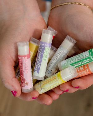 Violet lip balm — soft, powdery florals that taste the way the flower smells. Rinse Bath & Body Co.