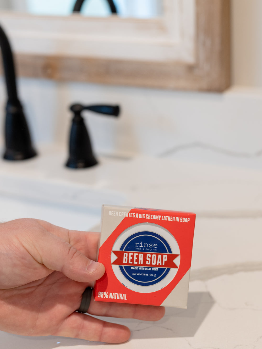 Blue Ribbon Beer Soap box lifted beside a matte black faucet — red-white-blue award label in clean vanity light
