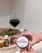 Cabernet body spread scooped from the tub and worked into skin — a thick shea-butter moisturizer carrying deep red wine and dark berry. Rinse Bath & Body Co.