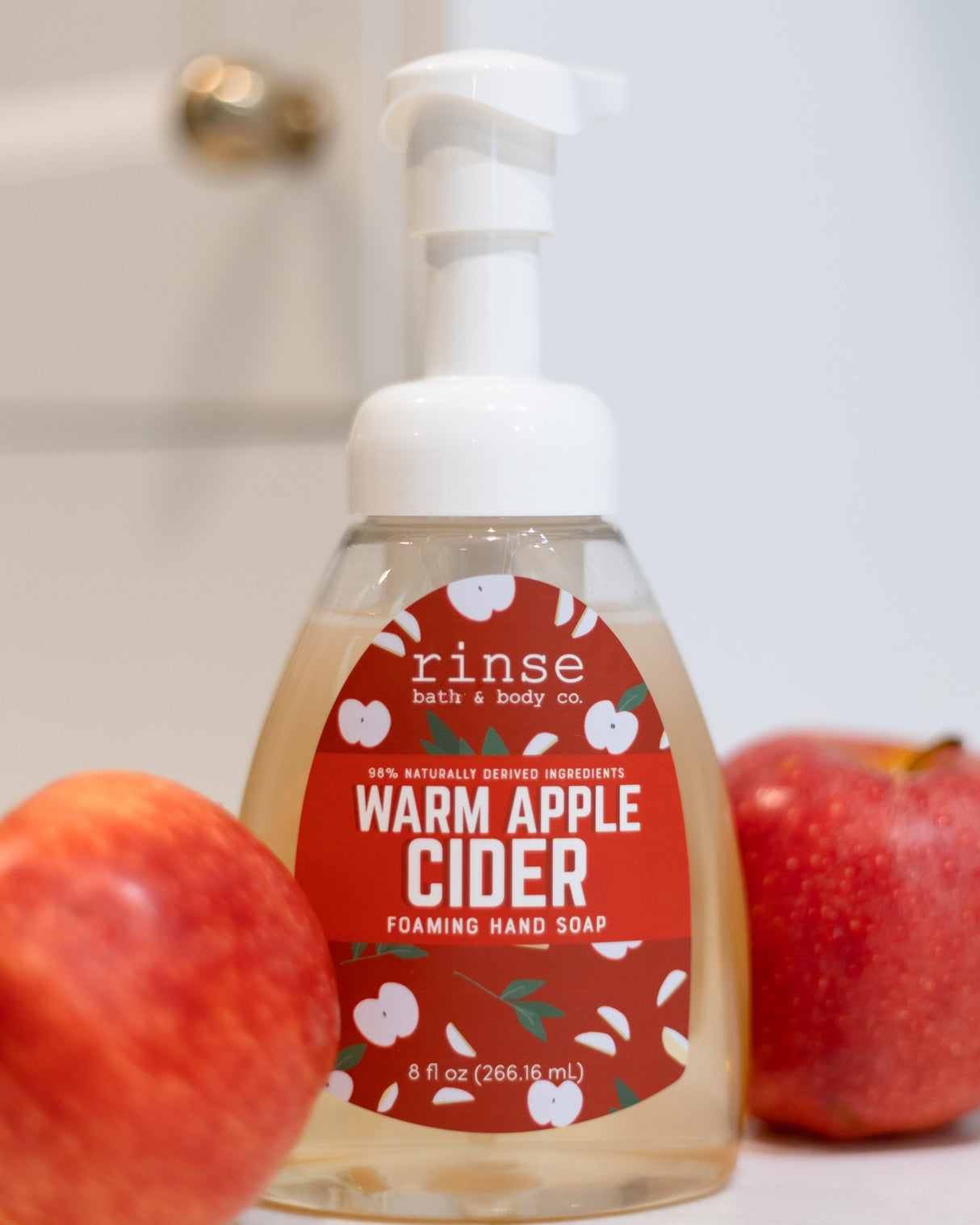 Warm Apple Cider foaming hand soap styled with whole apples