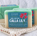 Teal-cream Calla Lily soap on textured lace mat — cozy white fabric in soft studio light