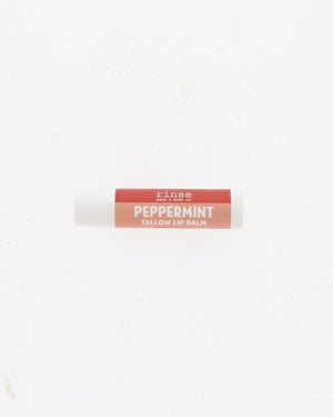 A single tube of Rinse Peppermint Tallow Lip Balm centered on a plain white background.