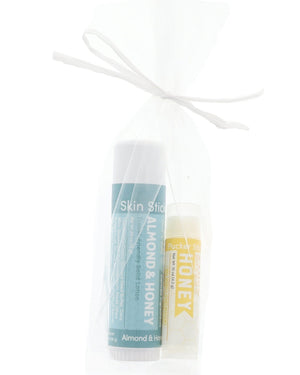 Almond & Honey Skin Stick and Honey Pucker Stick tucked in a sheer white mesh bag — gift-ready duo on bright white