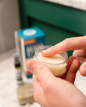 A hand working Rinse Conditioning Beard Balm into a full beard — cocoa butter and jojoba softening coarse facial hair. Rinse Bath & Body Co.