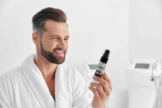 Man holding Rinse Bath & Body Beard Oil and smiling.