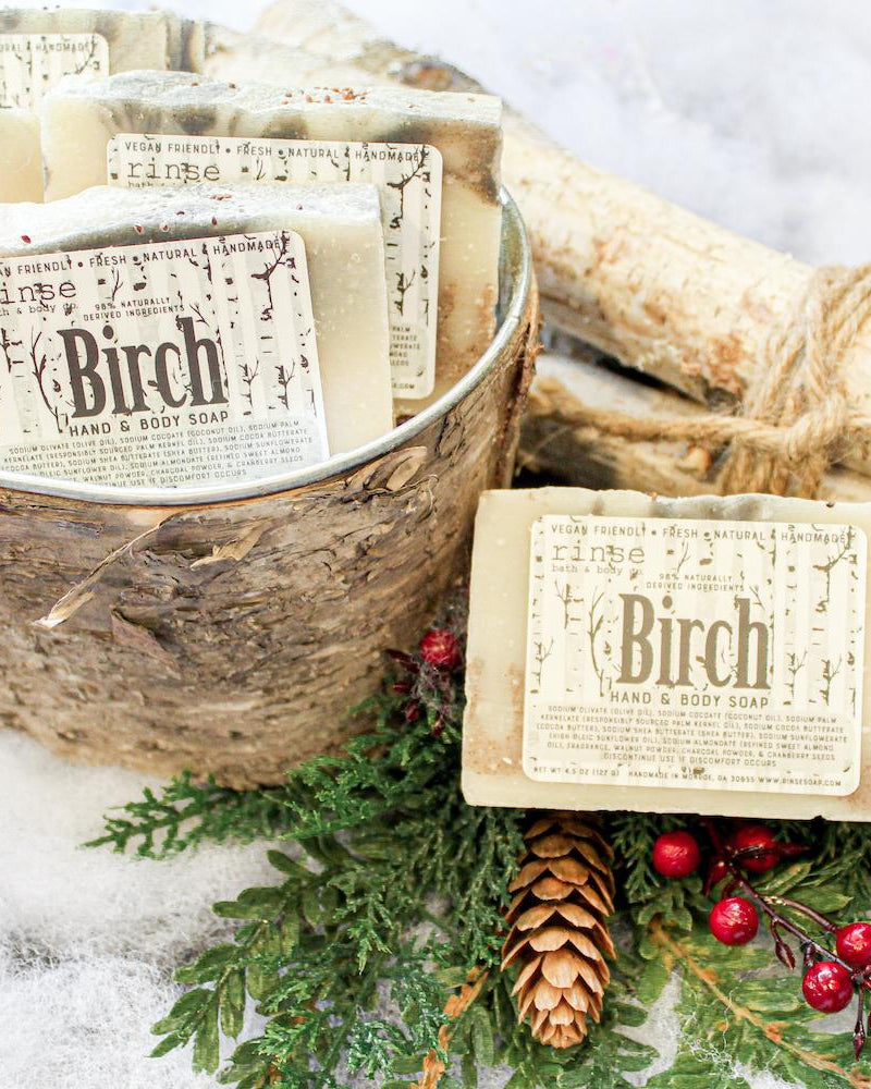 Birch bar soap from the side, showing the poured charcoal swirl through a cocoa-butter base. Rinse Bath & Body Co.