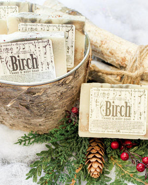 Birch bar soap from the side, showing the poured charcoal swirl through a cocoa-butter base. Rinse Bath & Body Co.