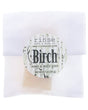 Birch soap slice peeks through glassine with birch-bark sticker — sample bar on clean bright white