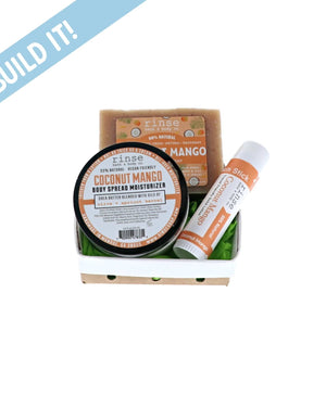 Coconut Mango Moisture Bundle sits in a white ceramic berry basket — green crinkle paper and Build It banner on bright white