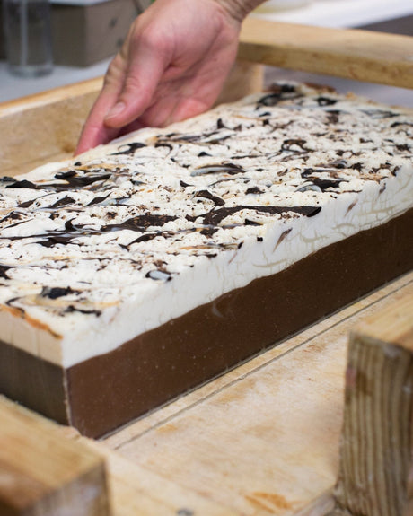 Chocolate bar soap from the side, showing the poured cocoa swirl through the bar. Rinse Bath & Body Co.
