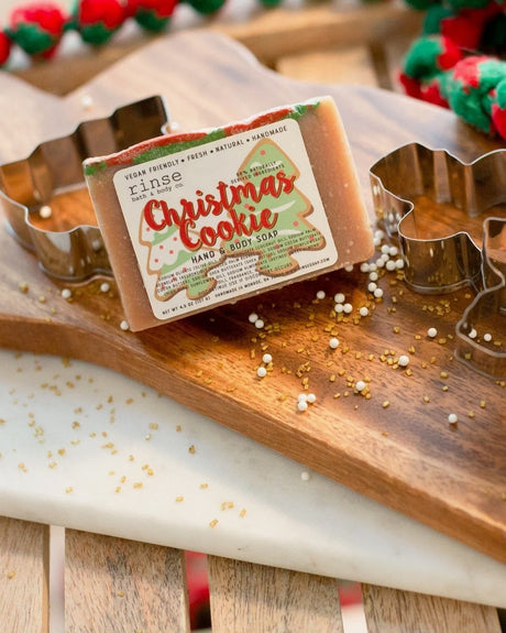 Christmas Cookie soap lifestyle on wood with cookie cutters — red-green swirl bar in warm bakery light