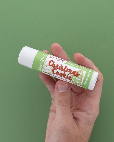 Christmas Cookie Skin Stick solid lotion stylized — sugar-cookie twist-up moisture bar on bright white