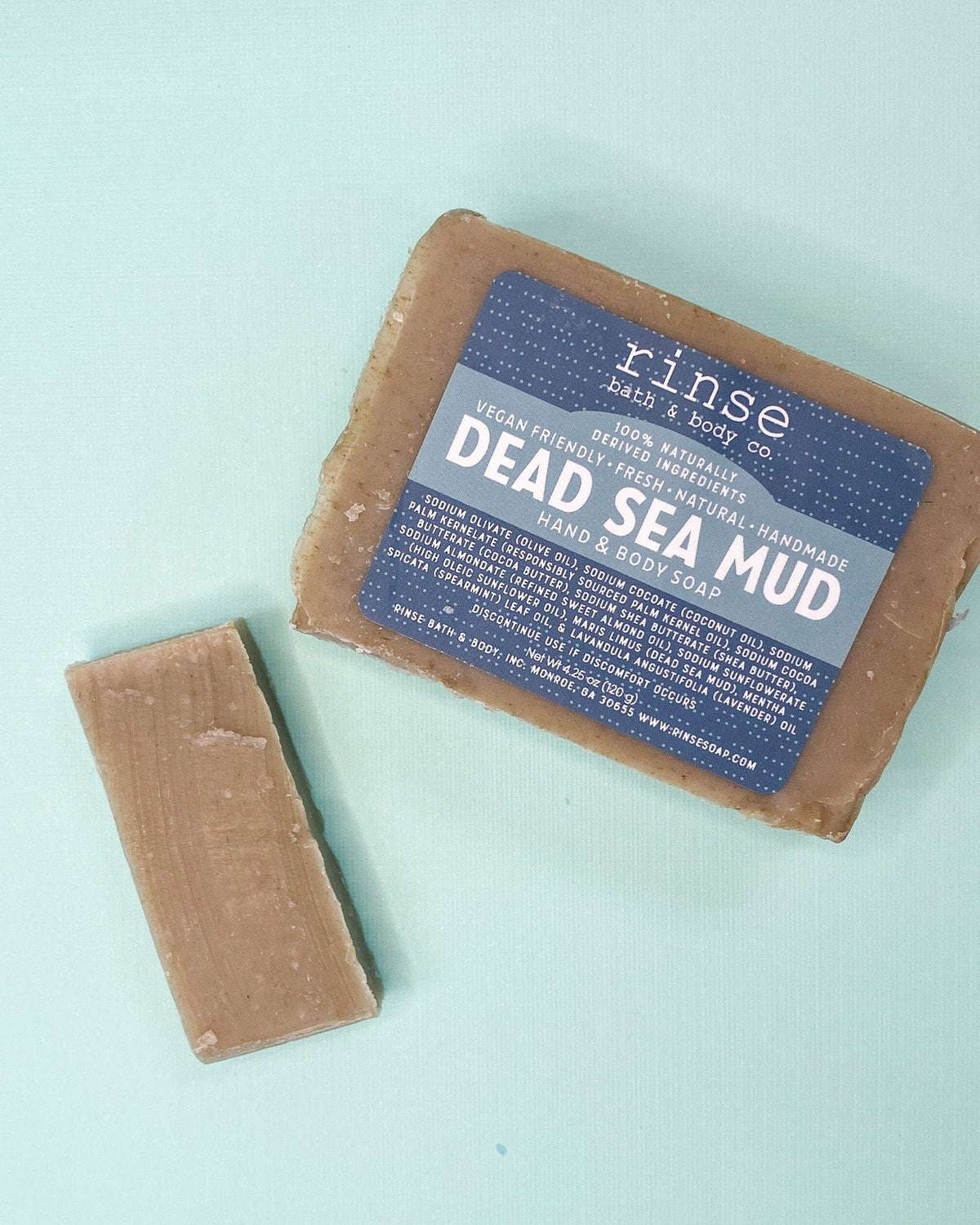Full Dead Sea Mud bar and bare slice on mint green — earthy taupe soap in soft flat-lay light