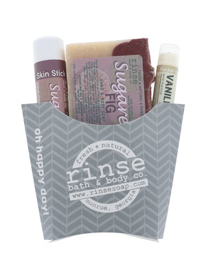 The Sugared Fig fry-box gift set in its grey chevron carton — Sugared Fig bar soap, Sugared Fig solid lotion skin stick and a Vanilla lip balm, ready to hand over. Rinse Bath & Body Co.