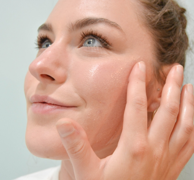 woman applying facial oil directly to skin with fingers